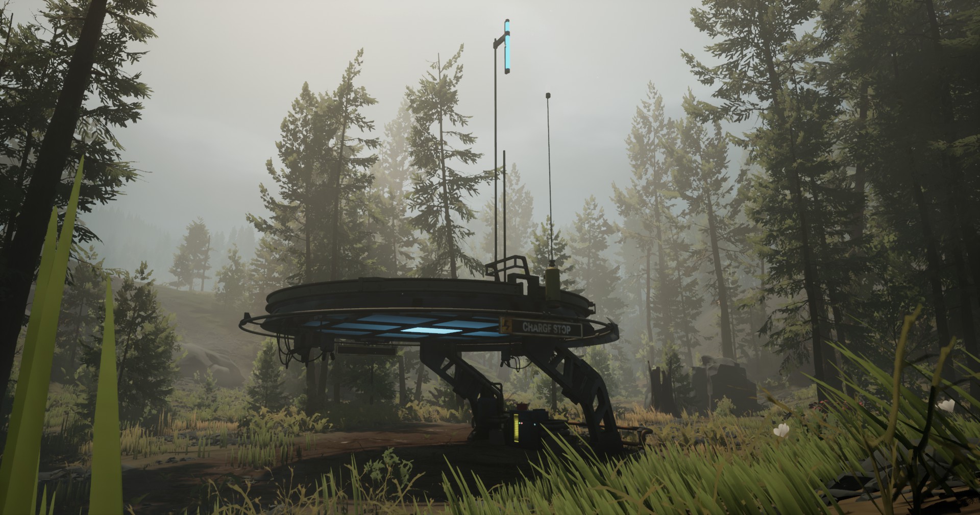 A large, disk-shaped structure large enough to drive a car under, held up by two arms on one side. It has a sign reading "Charge Stop" and two antennae mounted to its top. A small meter and other boxes are attached beneath the disk, between the arms.